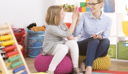 Counselor and child high fiving in a room with toys. 